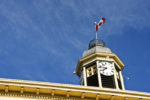 Upwards view of clock tower with Canada’s flag on top of it